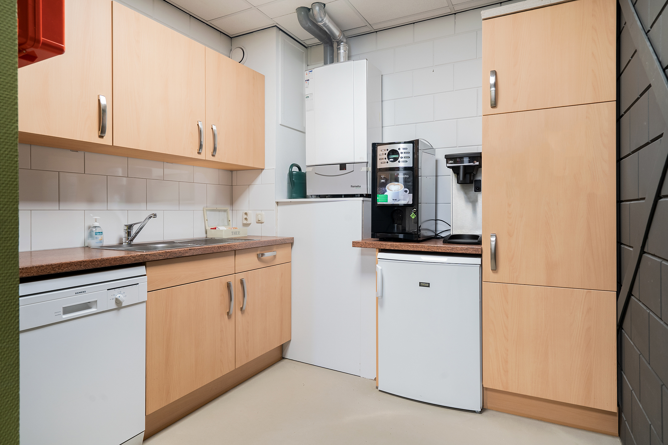 Dit is het keukentje die bij het kantoor behoort. Hier kan je lekkere koffie maken, de vaat doen en de koelkast gebruiken. 
